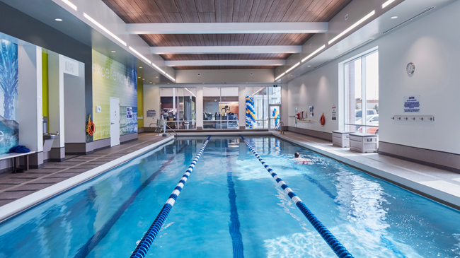 Person lap swimming in the indoor lap pool at LA Fitness in Mississauga, Ontario
